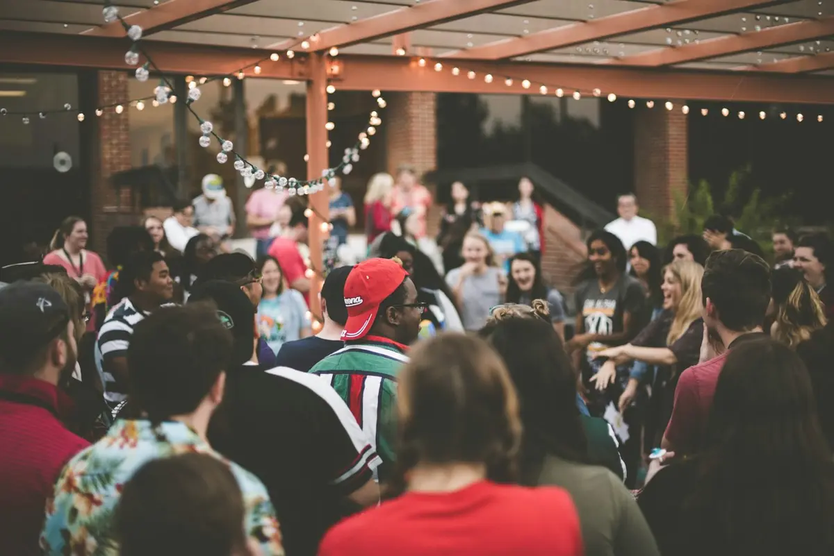 Crowd dancing under string lights at night