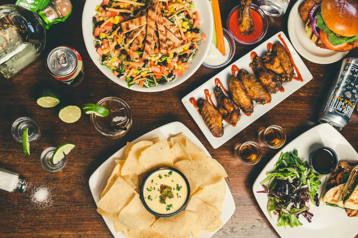 Spread of shared street food dishes on a wooden table